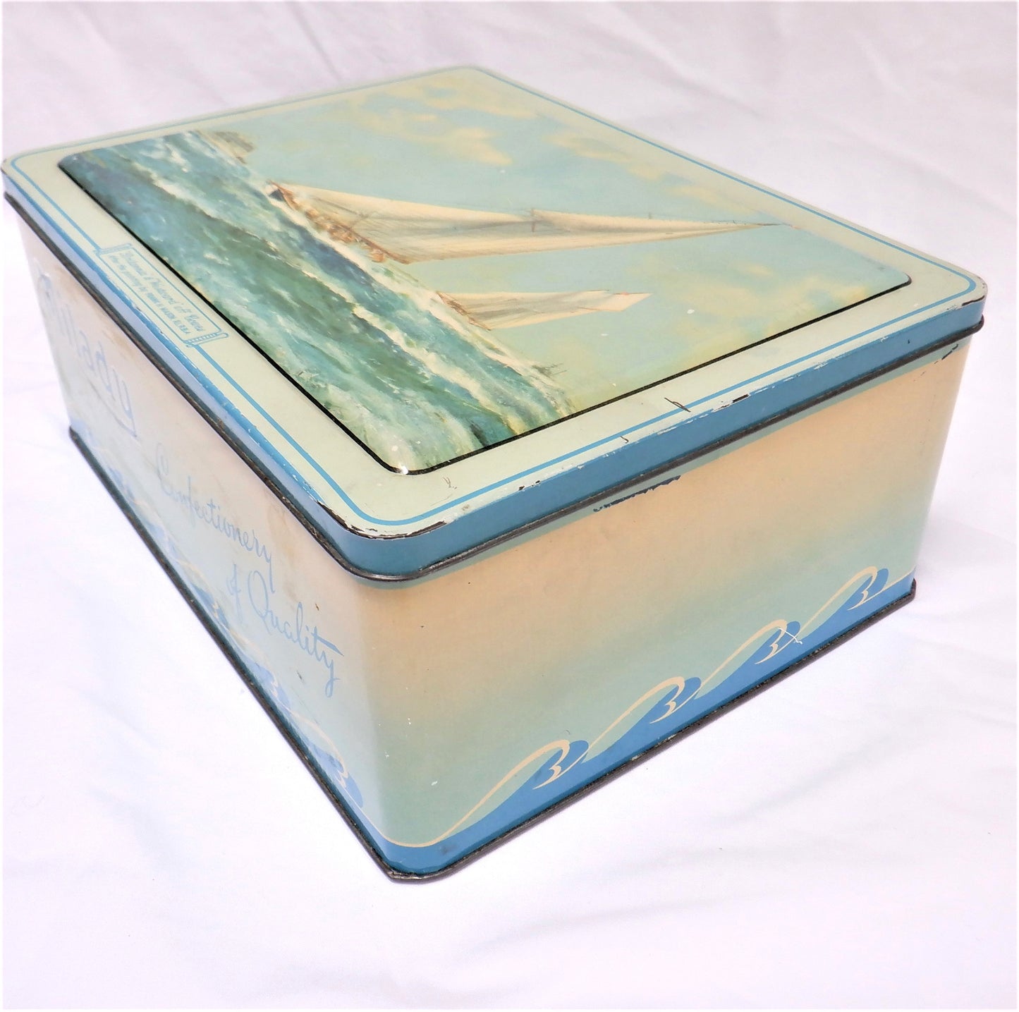 An Antique Milady Confectionery Tin displaying the famous painting by Frank H. Mason: 'BRITANNIA & WESTWARD OFF COWES'
