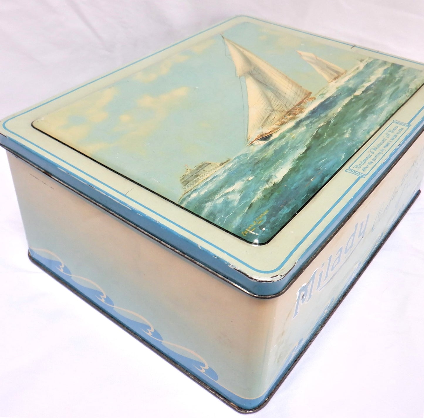 An Antique Milady Confectionery Tin displaying the famous painting by Frank H. Mason: 'BRITANNIA & WESTWARD OFF COWES'