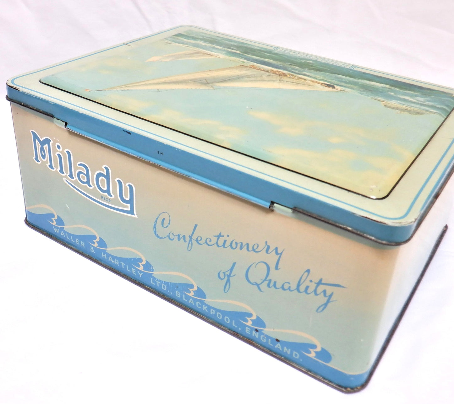 An Antique Milady Confectionery Tin displaying the famous painting by Frank H. Mason: 'BRITANNIA & WESTWARD OFF COWES'