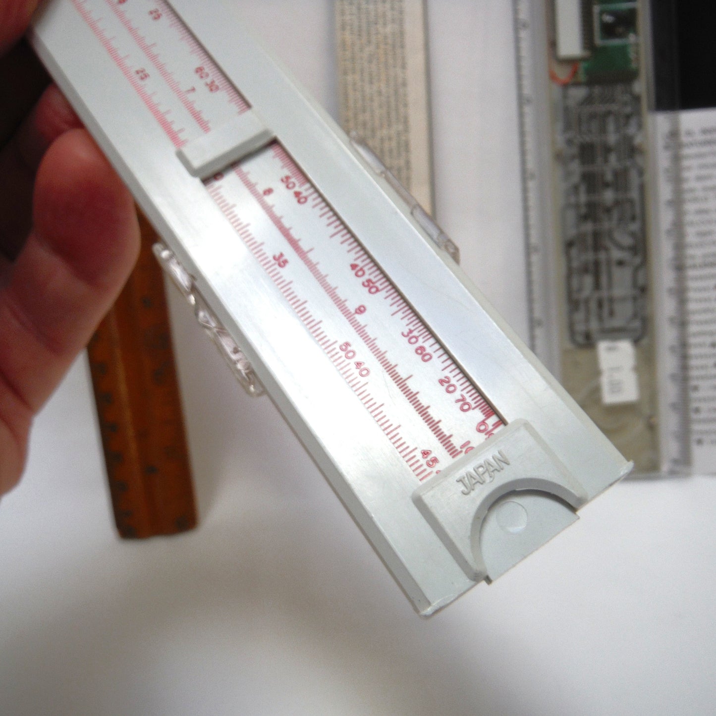 TRIO OF MEASURING DEVICES THROUGH THE AGES: Wood Ruler, Slide Ruler, and Electronic Ruler