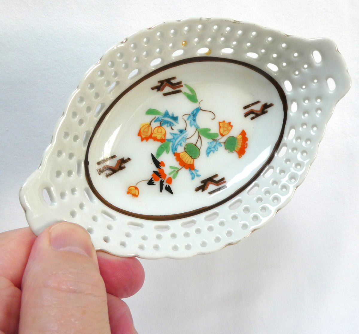 Vintage reticulated porcelain trinket dish featuring a delicate, pierced lattice rim and integrated small handles from Japan