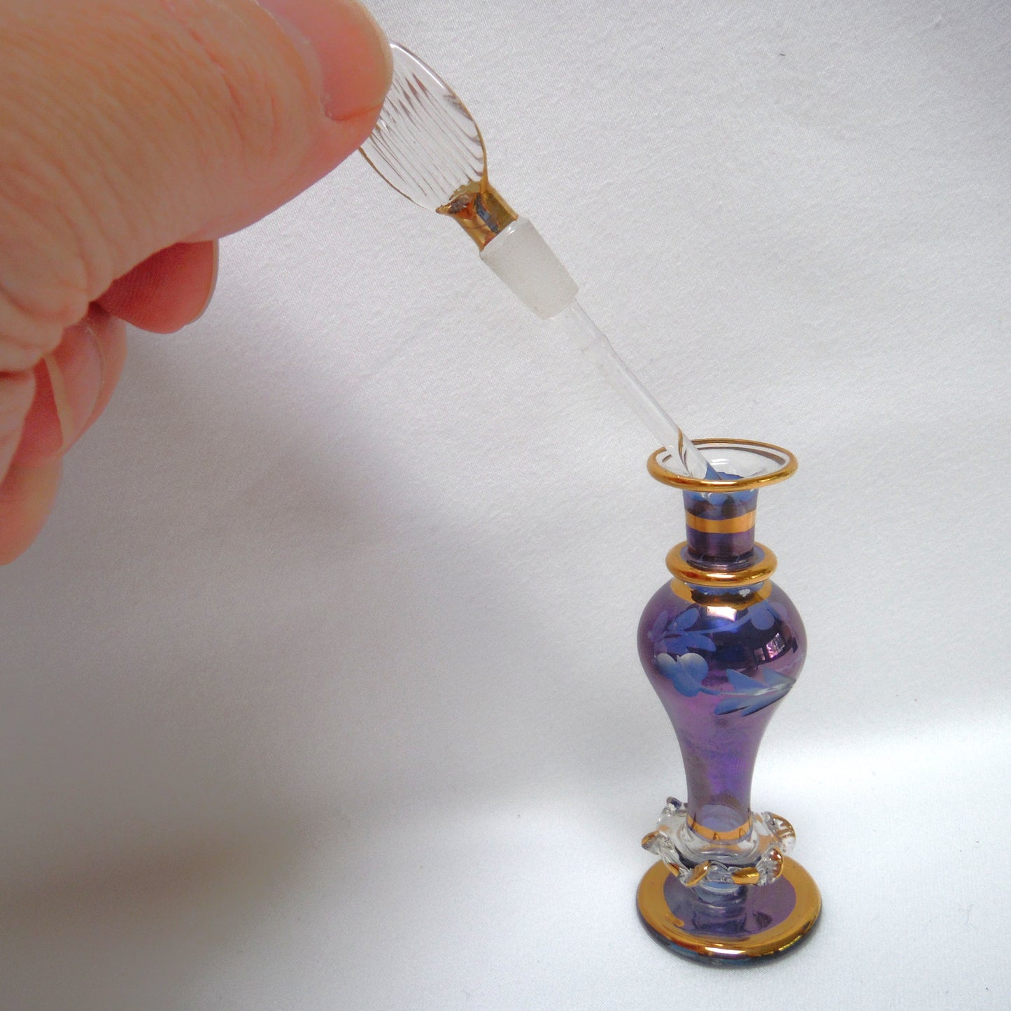 MINIATURE EGYPTIAN PERFUME BOTTLE: 'Nefertitis Tears 18 K gold glided, amethyst toned, mouth blown, hand-cut'